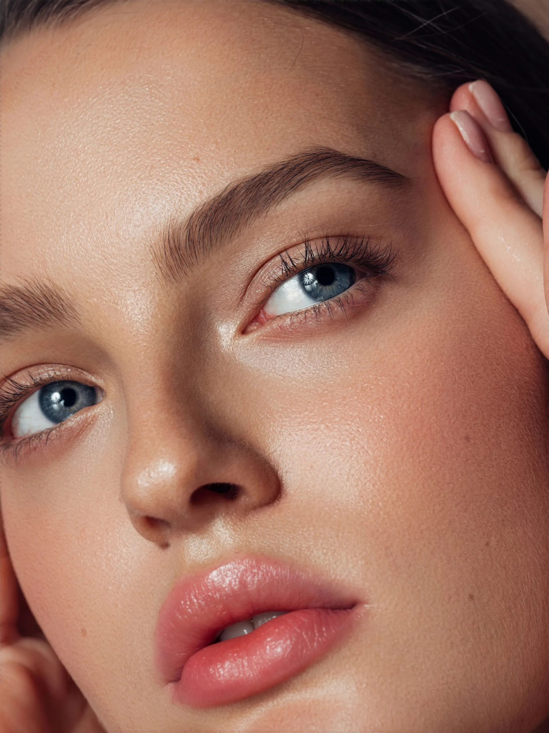Portrait féminin en gros plan mettant en valeur une peau lumineuse et une beauté naturelle en lumière douce