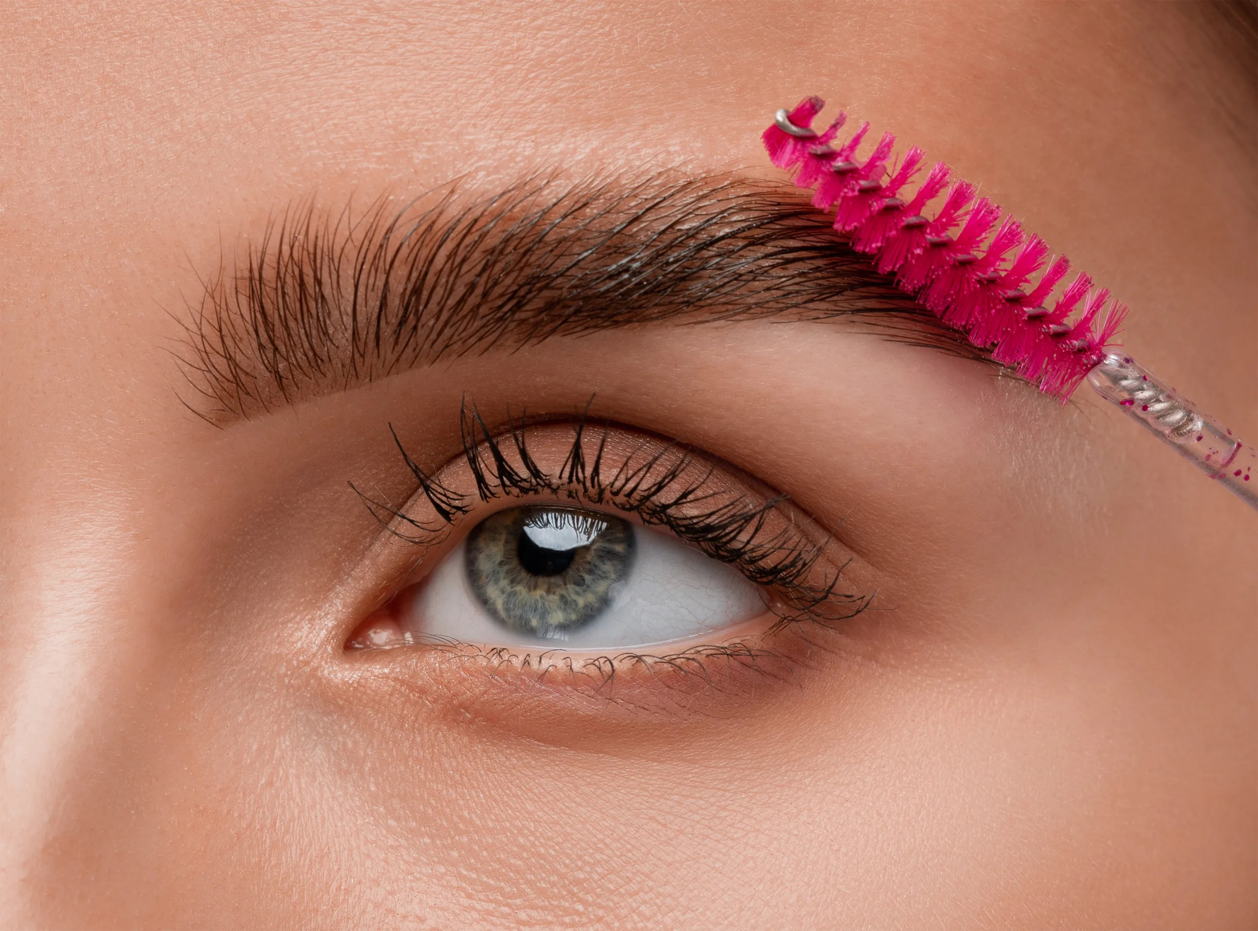 Esthéticienne réalisant une lamination des sourcils pour un résultat structuré et naturel